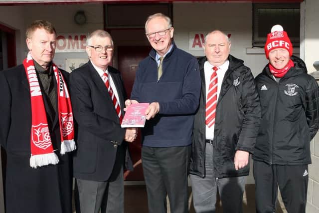 Robson Davison (centre), author of 'The Comrades, presents Trevor McCann, chairman, with the first copy of the special centenary book. Looking on, from left to right, are Seamus Reid, Reid Black Solicitors; Robert Fleck, treasurer and Justyn Wallace, committee member. Picture by Freddie Parkinson.