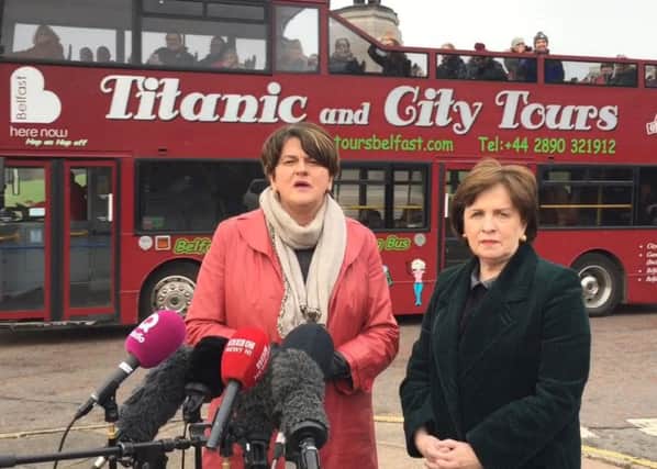 A tour bus passes behind DUP leader Arlene Foster (left) and party MEP Diane Dodds as they give press conference outside Stormont. Photo: David Young/PA Wire