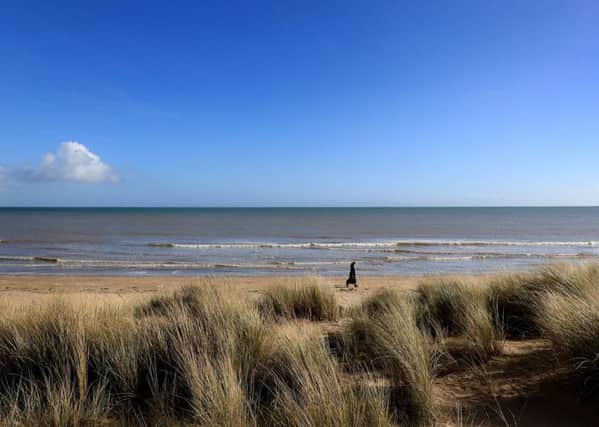 A lady walks in the sunshine along the beach in Greatstone, Kent as temperatures rise to record levels for February.
 Picture: Gareth Fuller/PA Wire