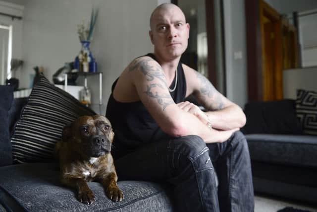 Chris Bennett, an army veteran who has tried to take his life a number of times, with his dog Tasty in his Belfast home. Photo: Pacemaker Press.