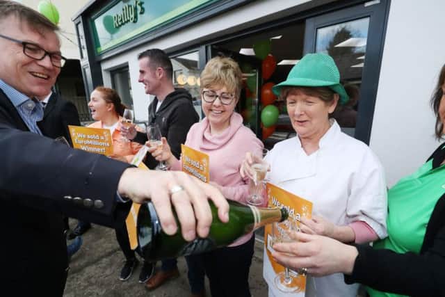 Michale Hayes (left) from the National Lottery pours champgne as Les Reilly (centre) and the staff of Reilly's Daybreak in Naul, Co Dublin, celebrate selling the EuroMillions 175 million winning lotto ticket