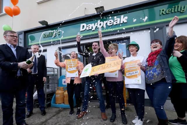 Michale Hayes (left) from the National Lottery sprays champagne as Les Reilly (centre) and the staff of Reilly's Daybreak in Naul, Co Dublin, celebrate selling the EuroMillions 175 million winning lotto ticket