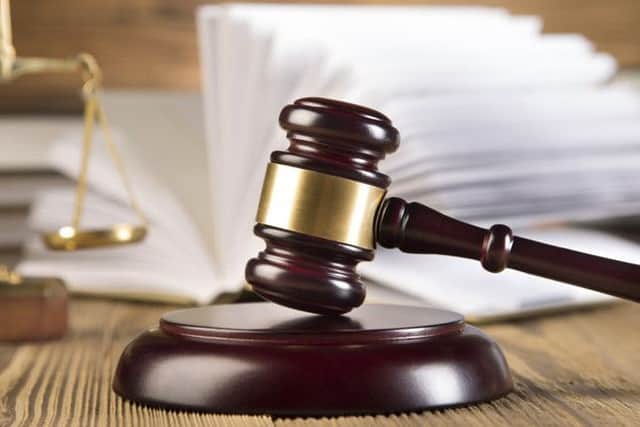 Golden scales of justice, gavel and books wood brown background