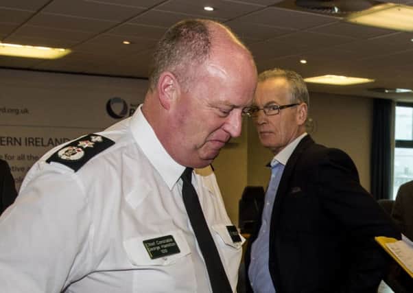 PSNI Chief Constable George Hamilton leaving after speaking to the press, as Sinn Fein's Policing Board member Gerry Kelly looks on