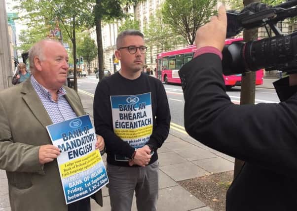 Sinn Fein's Fra McCann and Niall O Donnghaile outside the Bank of Ireland HQ in Belfast on 1 September 2017, protesting at its decision to withdraw Irish from ATMs due to lack of demand