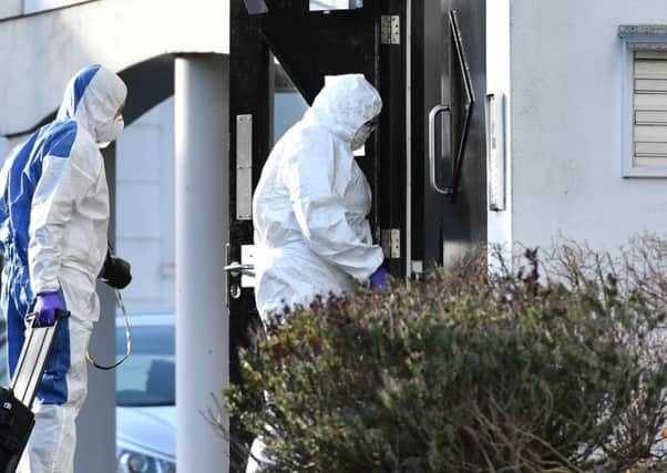 Forensic officers enter an apartment complex where the bodies of a man, woman and teenage girl were discovered earlier on Thursday. (Photo: Pacemaker)