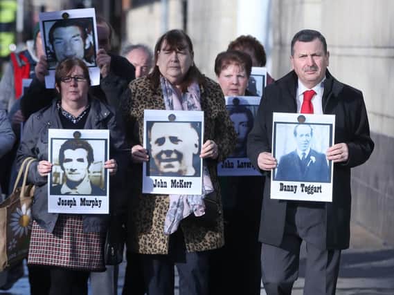 Family members hold images of those who died in disputed circumstance in Ballymurphy in 1971, outside Laganside Courts in Belfast as the inquest into their deaths continues.