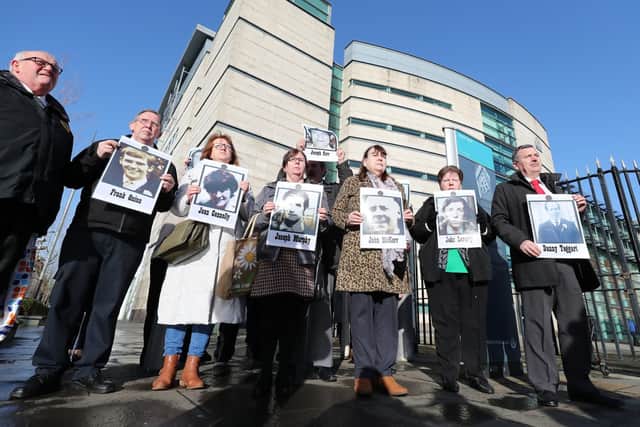 Family members hold images of those who died in disputed circumstance in Ballymurphy in 1971, outside Laganside Courts in Belfast as the inquest into their deaths continues