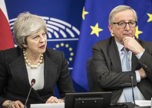 Prime Minister Theresa May and European Commission President Jean-Claude Juncker attend a media conference at the European Parliament in Strasbourg on Monday. (AP Photo/Jean-Francois Badias)