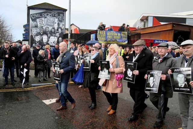 Relatives and supporters of the victims of the 1972 Bloody Sunday killings hold images of those who died as they march from the Bogside area to the Guildhall for the PPS announcement on prosecutions. Pic: PAUL FAITH/AFP/Getty Images)