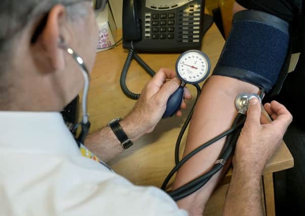 File photo dated 10/09/14 of a doctor checking a patient's blood pressure. Photo credit: Anthony Devlin/PA Wire
