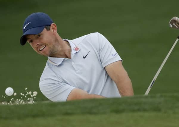 Rory McIlroy hits out of the bunker on the second hole during a practice round for the Masters