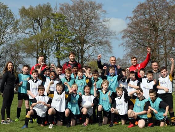 Pupils and staff from Edenderry Primary School, Portadown, with Ulster players Darren Cave, Iain Henderson and Jordi Murphy during a Kingspan Coaching Masterclass
