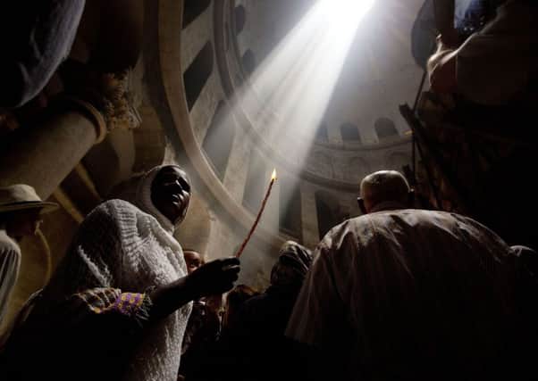 A Christian pilgrim holds a candle during Easter Sunday at the Church of the Holy Sepulchre, traditionally believed to be the burial site of Jesus Christ, in Jerusalem's Old City,  May 1, 2016