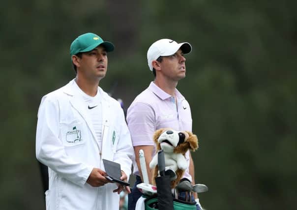 Rory McIlroy of Northern Ireland stands with caddie Harry Diamond on the 14th hole during the final round of the Masters at Augusta National Golf Club