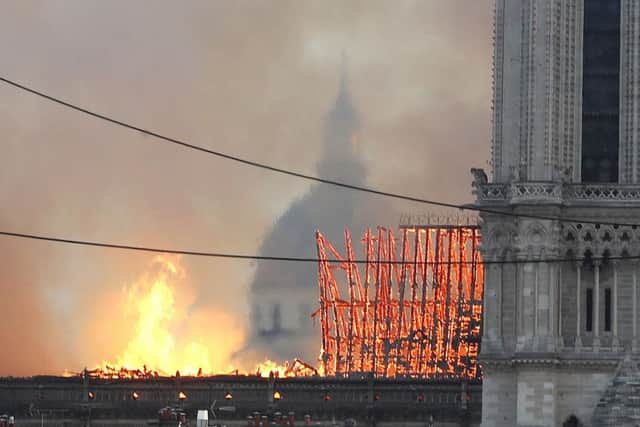 Flames rise from Notre Dame cathedral as it burns in Paris, Monday, April 15, 2019. Massive plumes of yellow brown smoke is filling the air above Notre Dame Cathedral and ash is falling on tourists and others around the island that marks the center of Paris. (AP Photo/Thibault Camus)