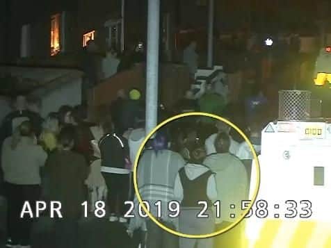 An image taken from the C.C.T.V. footage issued by the P.S.N.I. shows Lyra McKee in the crowd moments before a masked gunman opens fire.