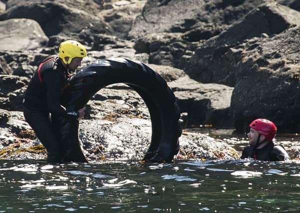 Divers remove a tyre from the sea at the Giant's Causeway