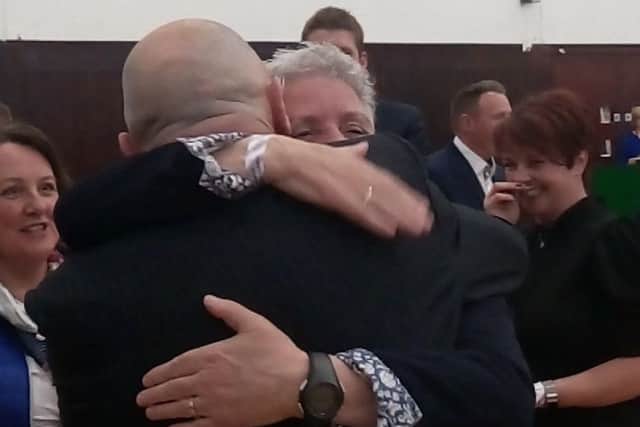 A man hugs Alison Bennington following her win