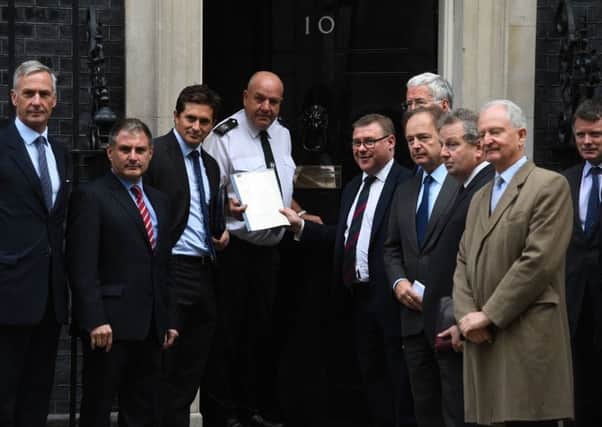 Johnny Mercer, third from left, beside policeman, joins other MPs or ex MPs to hand in a petition to 10 Downing Street last October signed by 104 MPs and peers and senior ex military figures calling for lasting legal protection for veterans. Among them, pictured third from right, is Danny Kinahan, the former Ulster Unionist Party MP. Photo: Kirsty O'Connor/PA Wire