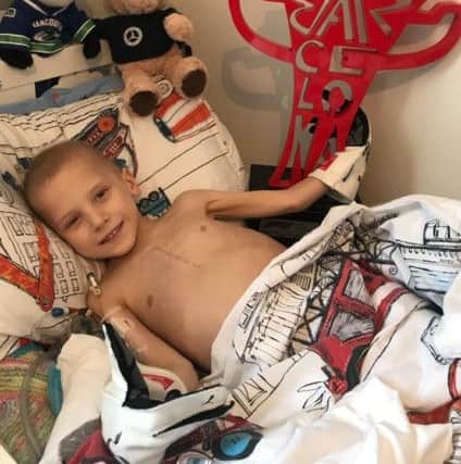 Five-year-old Harry Shaw, who has been diagnosed with a rare form of bone cancer, in bed with the Spanish Grand Prix Trophy and Lewis Hamilton's Race gloves at their home in Redhill, Surrey. Photo: The Shaw Family/PA Wire