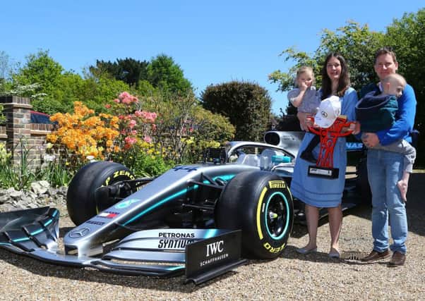 Five-year-old Harry Shaw, who has been diagnosed with a rare form of bone cancer, is carried by his father James with mother Charlotte and sister Georgia to view a replica of Lewis Hamilton's Formula 1 car outside their home in Redhill, Surrey. Photo: Gareth Fuller/PA Wire