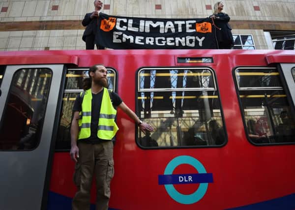 File photo dated 17/04/19 of climate activists Cathy Eastburn, 51 from Lambeth, south London and Luke Watson, 29, of Manuden, Essex,(both top) and Mark Ovland, 35 of Somerton, Somerset, glued to a Docklands Light Railway train at Canary Wharf station