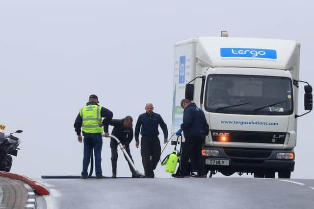 The clean-up operation at Black Hill, where riders reported the road surface to be extremely slick.