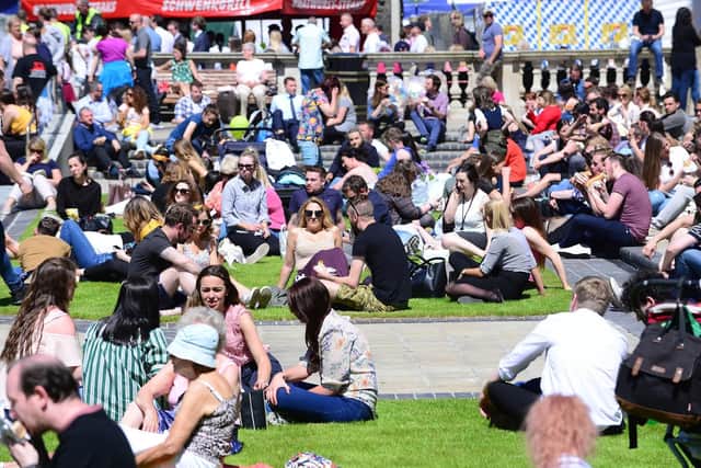 People enjoying the warm and sunny weather at Belfast City Hall in May 2018. (Photo: Arthur Allison/Pacemaker)