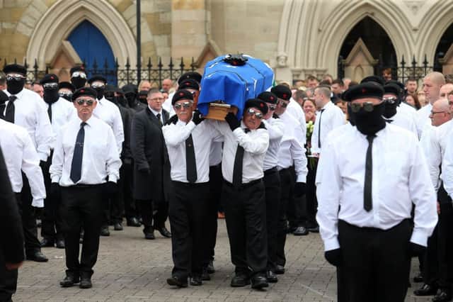 A crowd of men with their faces covered and wearing berets led the funeral procession to St Peters Cathedral for the funeral of Martin McElkerney