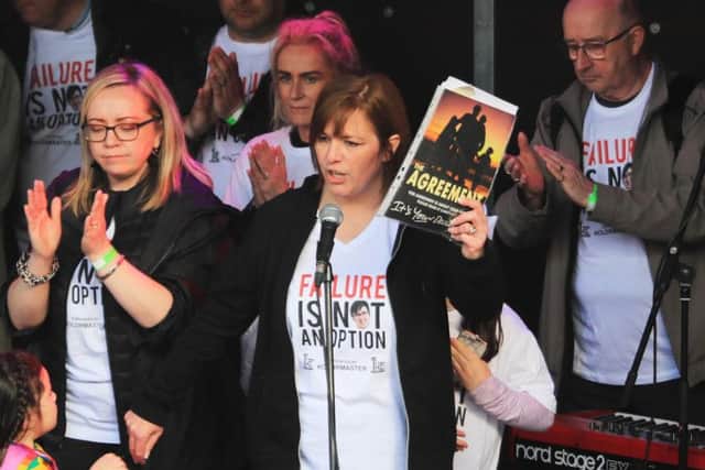 Nichola Corner, the sister of murdered journalist Lyra McKee, holding a copy of the cover of The Agreement at the end of her speech at the Guildhall as friends of Lyra arrived at the end of their three-day peace walk from Belfast. Pic: Liam McBurney/PA Wire