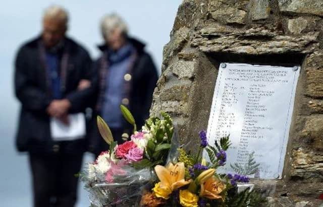 Relatives quietly remember their loved ones at the cairn built in their memory on the Mull of Kintyre