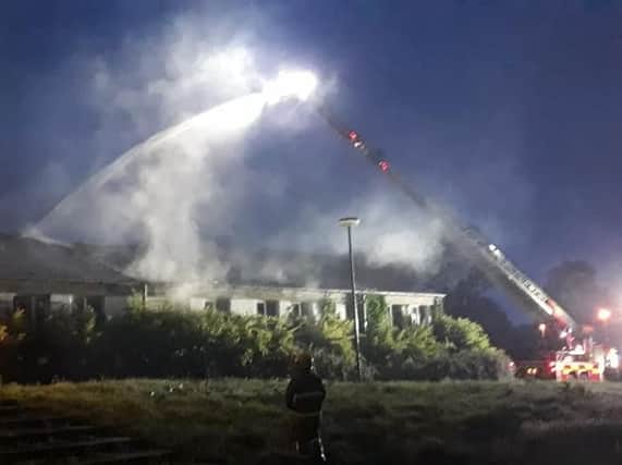 Firefighters use an aerial platform to battle the blaze at the disused Parkhall College building in Antrim. Pic: NIFRS North