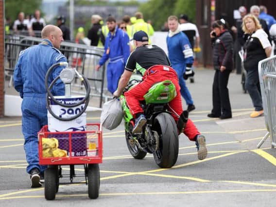 Machines are wheeled away from Parc Ferme after racing on Wednesday was cancelled due to poor weather.