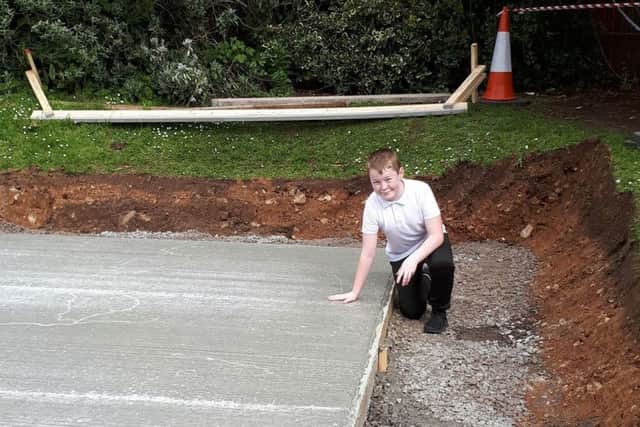Cormac, 11, leaves his handprint in the concrete foundations for the outdoor classroom at Ballymacward Primary School.
