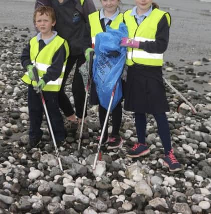 Erin McKeown, Ulster Wildlife QUB placement student, helps pupils from Seaview Primary School make a positive difference to Glenarms wildlife by removing litter from the strand.