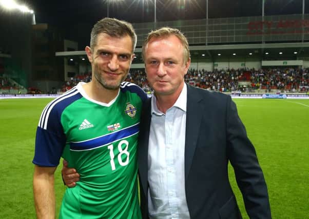 Northern Irelands Aaron Hughes with manager Michael ONeill after winning his 100th cap for his country