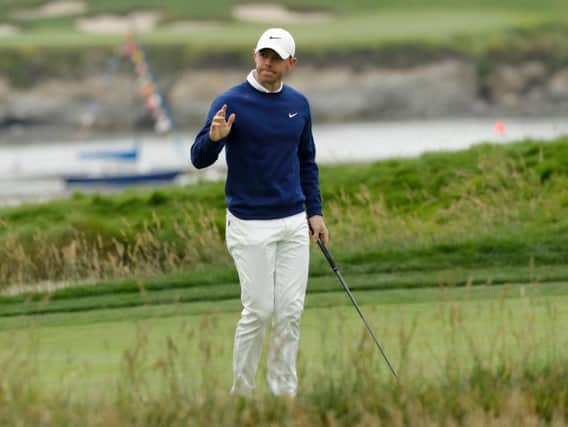 Rory McIlroy, of Northern Ireland, waves after his putt on the 17th hole during the first round of the U.S. Open Championship