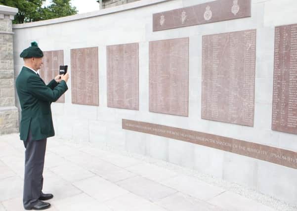 Ex Serviceman David Baird takes a picture of the new memorial wall.