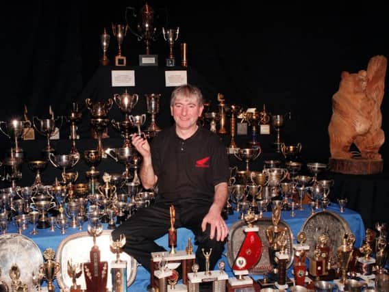 Motorcycling legend Joey Dunlop pictured with some of the vast haul of silverware he won during his illustrious career. The Ballymoney man was tragically killed in a crash in Estonia in 2000.