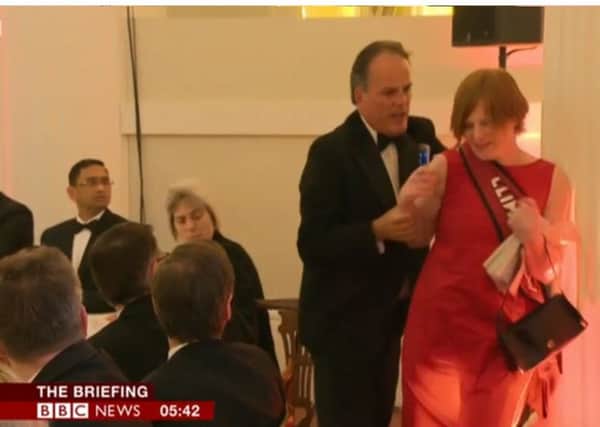 . Video grab taken from the BBC of Foreign Office Minister Mark Field showing him physically removing a climate change protester from a dinner in the City of London where Chancellor Philip Hammond was giving a speech