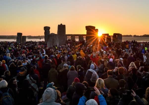 The sun rises between the stones and over crowds at Stonehenge where people gathered to celebrate the dawn of the longest day in the UK yesterday, Friday June 21, 2019. The days will now get shorter until the winter solstice on December 21. Photo: Ben Birchall/PA Wire