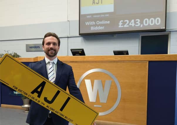 Auctioneer John Ardill with the £243,000 plate in Belfast