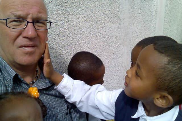 Charlie Graham with a child who was fascinated by the colour of his skin