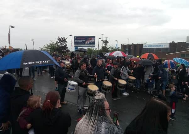 Bandsmen perform at Avoniel leisure centre, where the bonfire can be seen in the background on the far left