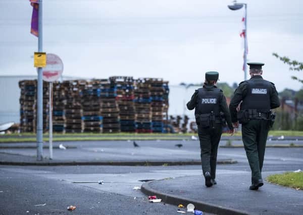 Two PSNI officers walking towards the 11th night bonfire at Avoniel Leisure Centre, after a statement was read out by a Belfast City Council worker from inside a PSNI vehicle requesting that people on council property vacate the area. Belfast City Council reaffirmed its decision yesterday for the third time, to remove materials from a bonfire site beside the centre. Pic by Liam McBurney/PA Wire
