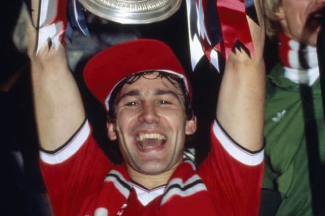 Manchester United captain Bryan Robson lifts the FA Cup in 1983