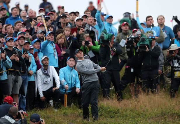 An expectant crowd watches Rory McIlroy chip from the rough on the 17th hole in the Open at Royal Portrush in a crucial moment last evening. "Even the way that he failed   seeming to be defeated by nerves at the huge task he had set himself of winning at home showed a vulnerable side to someone who can be supremely confident in his own gifts," writes Ben Lowry  Photo: Richard Sellers/PA Wire