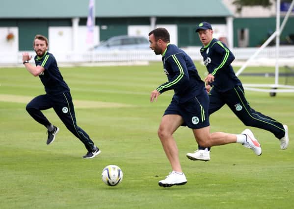 Ireland's Stuart Thompson (centre) warms up with a football during the nets session at Lord'. Pic by PA Wire.