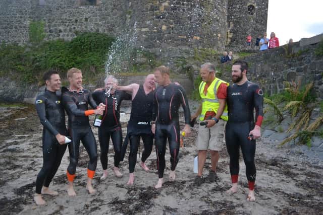 Popping the bubbly beside Carrickfergus Castle following the successful swim.